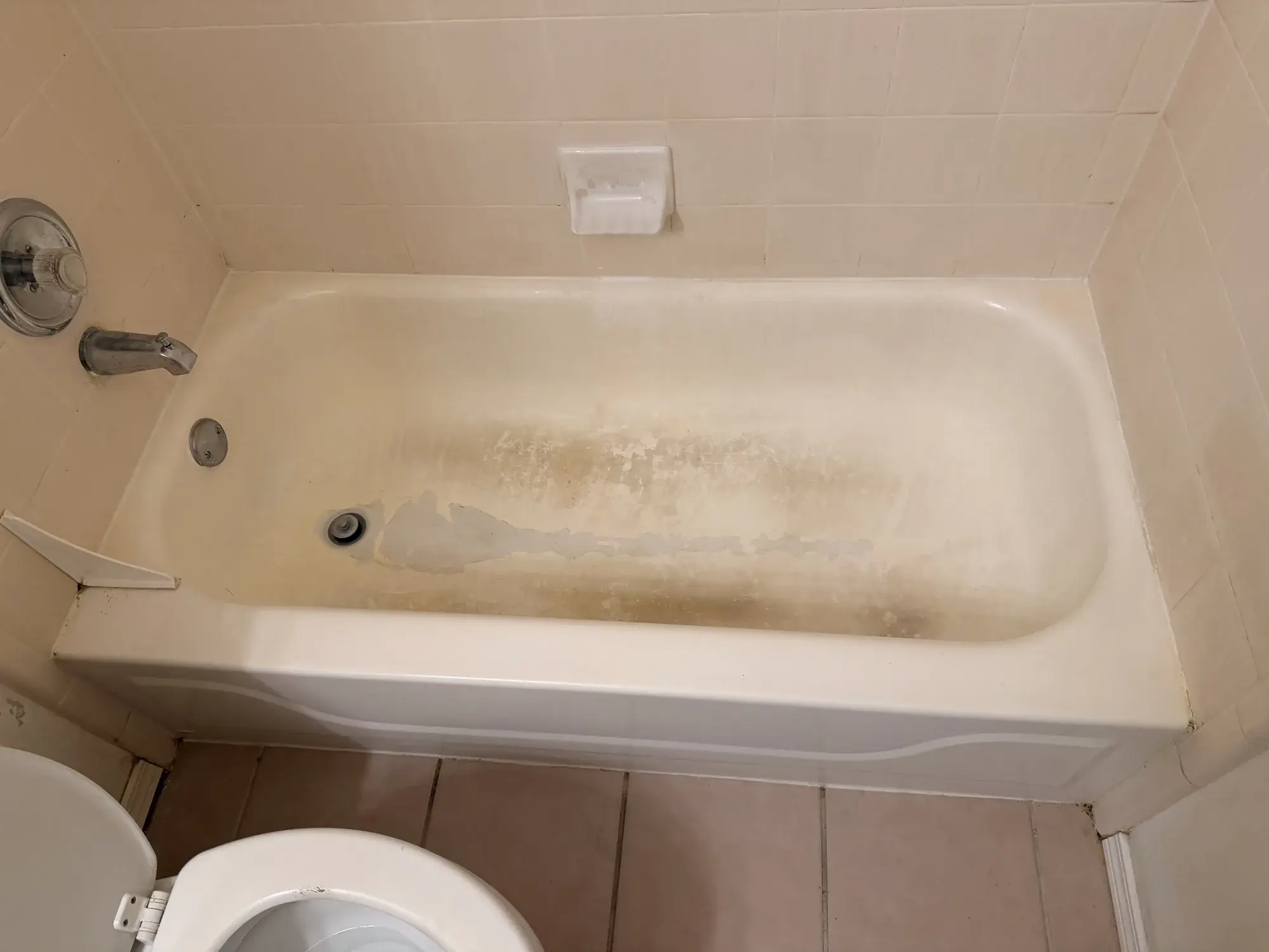Bañera antes del reesmaltado junto a azulejo beige